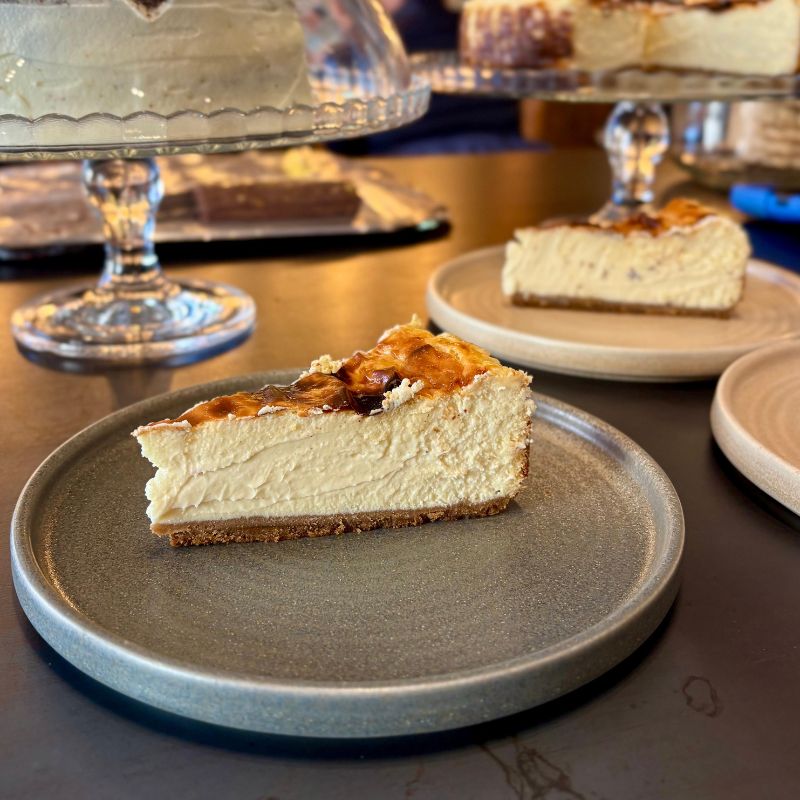 Dos trozos de la suculenta cheesecake de Mafrens: la tarta de queso del tío Luigi. Famosa por su toque de queso de cabra y base de galleta.